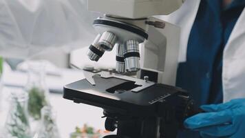 A person in a lab coat is looking at a microscope video