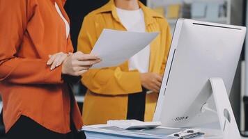 Two women are standing in front of a computer video
