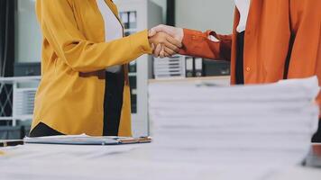 Two business people shaking hands over a desk video
