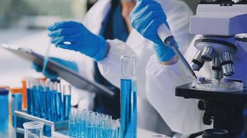 uma pessoa dentro uma laboratório casaco é trabalhando em uma microscópio video