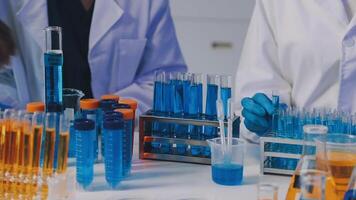 dois pessoas dentro laboratório casacos trabalhando com teste tubos video