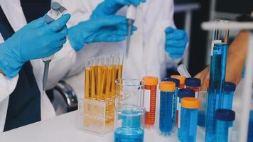 A group of people in lab coats and gloves are working on a test tube video
