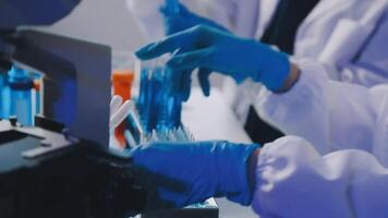 Two people in lab coats and gloves working on a machine video