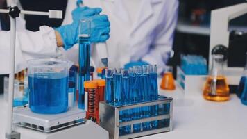 Two people in lab coats are working on a test tube video