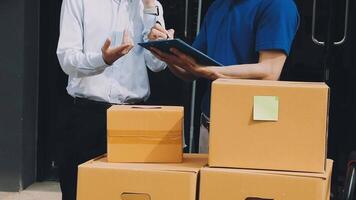 Two men standing near boxes with a tablet video