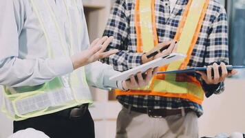 Two construction workers are standing in front of a table video