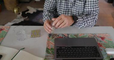 A man is using a laptop computer and a glass video