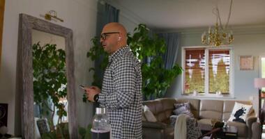 A man standing in a living room with a mirror video