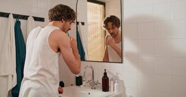 A man brushing his teeth in front of a mirror video