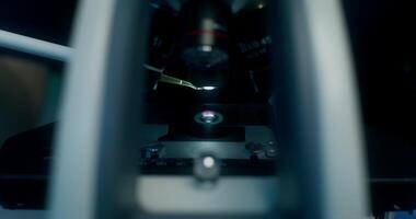 Close-up of glass and microscope lenses. A hand in a disposable glove drips liquid onto the glass with a pipette. Work in the laboratory video