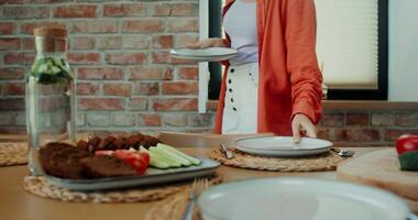 une femme permanent dans de face de une table avec assiettes video