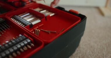 A person is holding a red tool box with a variety of tools video