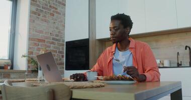 A woman sitting at a table with a laptop video