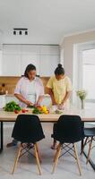 Two women standing at a table in a kitchen video