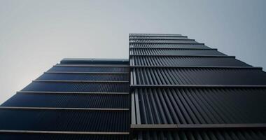 Bottom view of a modern skyscraper against a clear sky video