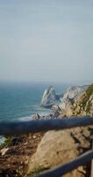 panorámico ver de el mar Lavado el rocoso costas y repisas. ver desde el parte superior de el montaña desde el observación cubierta mediante el cerca, vertical video