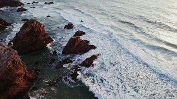 Top view of the peak rocks peeking out of the water, the seashore from a drone video