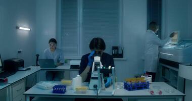 A woman in a lab coat is working on a computer video