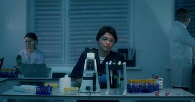 A woman in a lab coat is working on a computer video