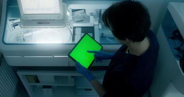 A man in a lab coat is holding a tablet computer video
