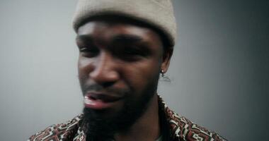 A man with a beard and hat is looking at the camera video