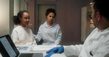 A doctor talking to a young girl and her mother video