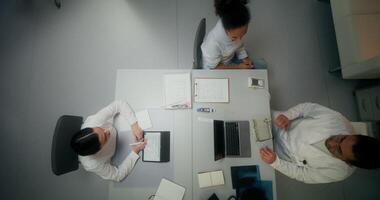 A group of people sitting at a table with laptops video