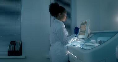A woman in a lab coat is using a computer video