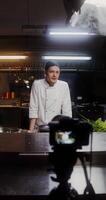 A man in a chef's uniform standing in front of a camera video