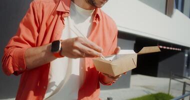A man is holding a box with food in it video
