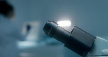 A microscope is shown in a dark room video