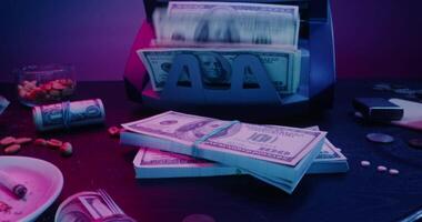 A pile of money on a table with a machine video