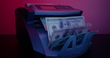 A money counting machine with a stack of cash video