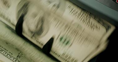 A close up of a stack of money being inserted into an atm machine video