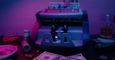 A money counting machine is sitting on a table with money and other items video
