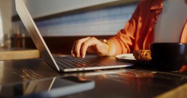 A person typing on a laptop computer with a cup of coffee video