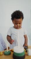 A woman and a child playing with a wooden block video