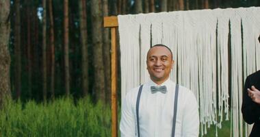 Two men in suits standing in front of a white backdrop video