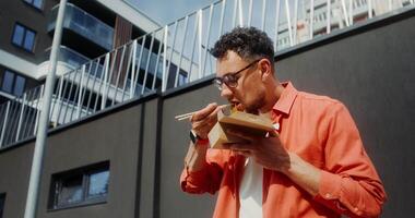 A man eating a meal outside of a building video