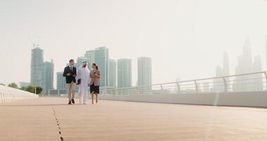 A man and woman walking on a bridge with a city skyline in the background video