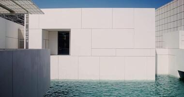 A white building with a pool in front of it video
