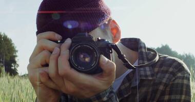A man taking a photo with a camera in a field video
