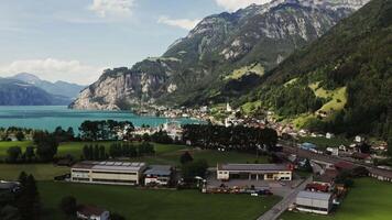 A town on the lake with a view of the mountain valley, drone . Scenic view of the Alpine mountains surrounding a beautiful large lake. video
