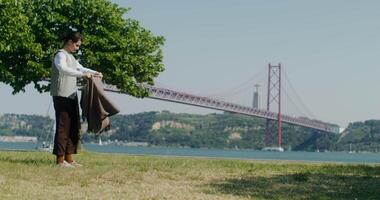 A man standing in front of a tree with a bridge in the background video