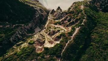 The drone flies over a mountain, a sandy beach with rocks sticking out of the water and moves to a view of the sea video