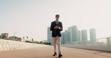 A man in a suit and tie walking on a bridge video