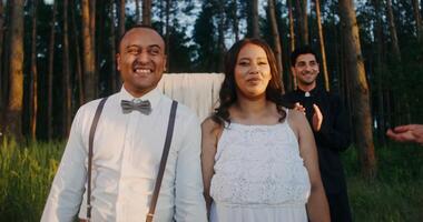 A man and woman are smiling while standing in a forest video