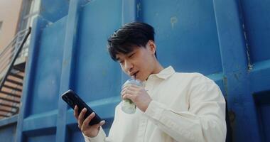 A man is holding a cell phone and drinking water video