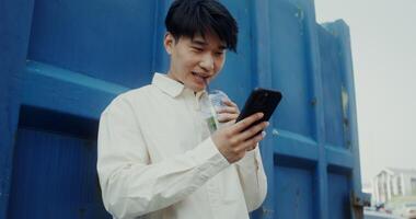 A man holding a cell phone and looking at it video