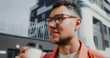 uma homem dentro óculos segurando uma café copo video